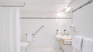 A modern bathroom with a toilet, bidet, hand dryer, and towel rack. - Alpha Hotel Canberra (Canberra)