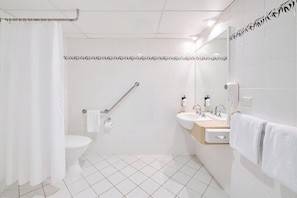 A modern bathroom with a toilet, bidet, hand dryer, and towel rack. - Alpha Hotel Canberra (Canberra)