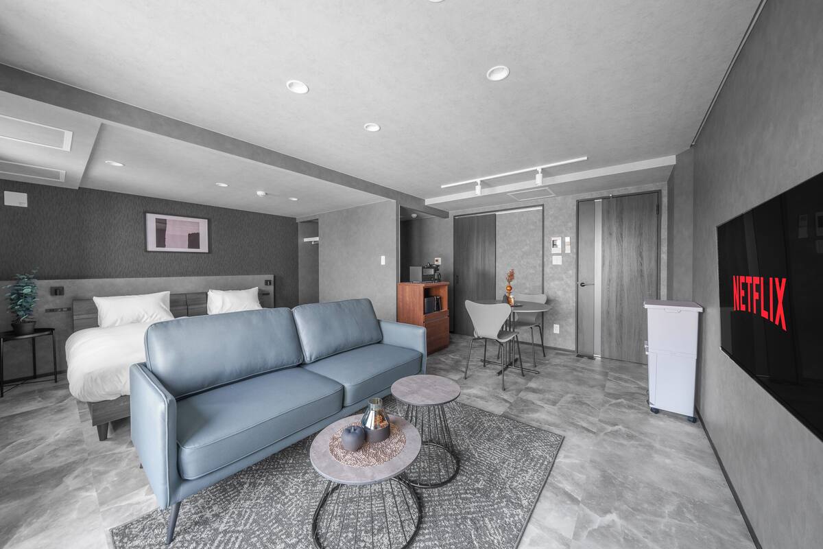 Ein modernes Wohnzimmer mit Sofa, Couchtisch und einem Essbereich mit Stühlen.