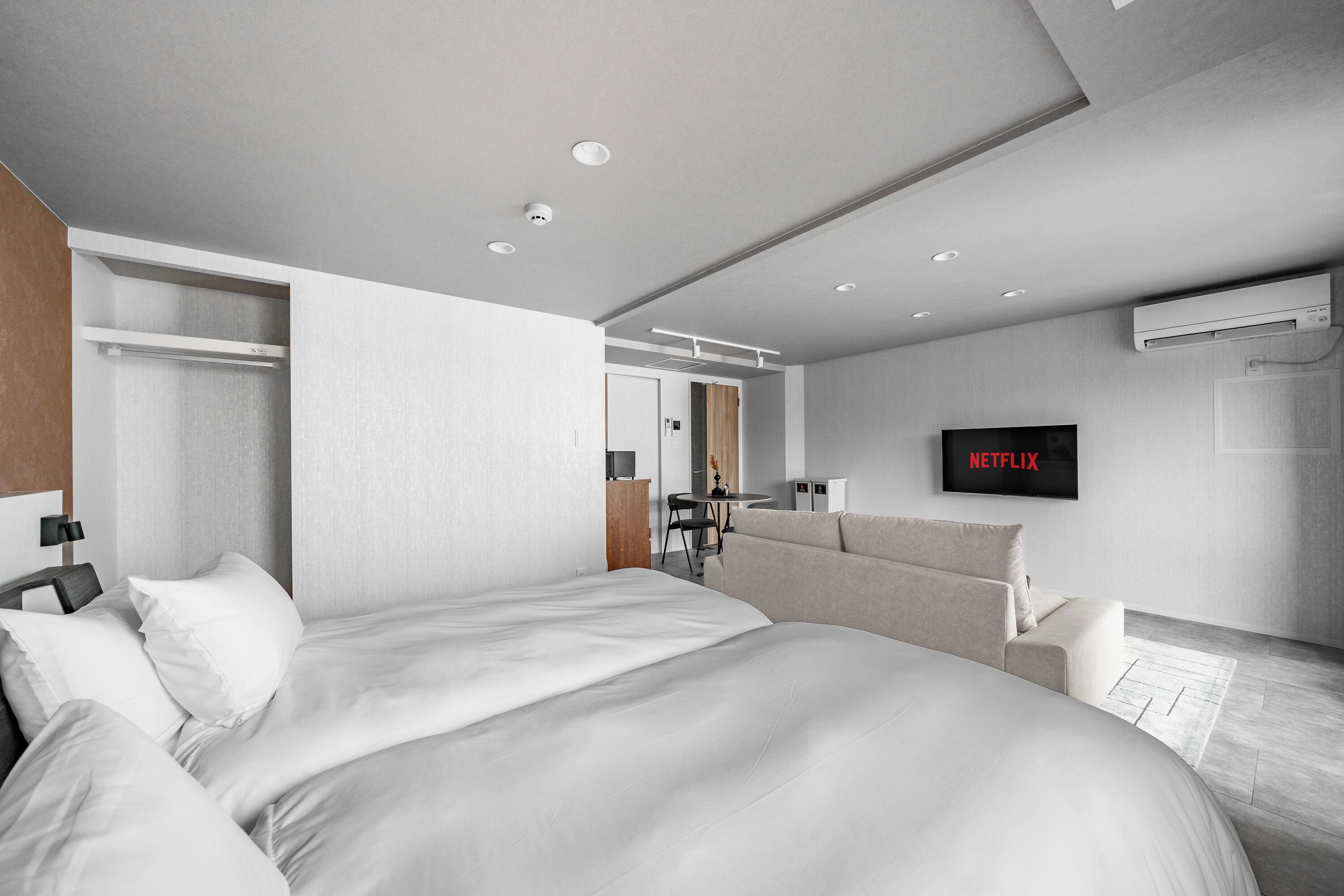 Una camera d'albergo moderna con un letto grande, una TV, una scrivania e un armadio.