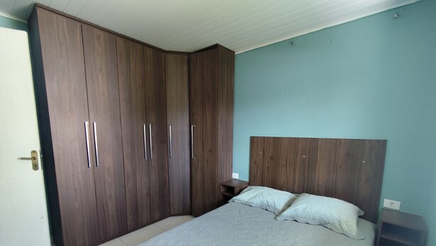 Ein Schlafzimmer mit einem Bett, einem Kleiderschrank und einem Nachttisch.