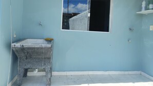 Ein Badezimmer mit Fenster, Waschbecken und Dusche.