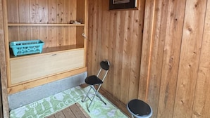 A wooden room with a bench, two chairs, a small table, and a framed picture on the wall. - turuyaryokan (Yamanouchi)