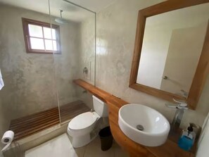 Ein Badezimmer mit Toilette, Waschbecken, Spiegel und Dusche.