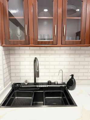 Una cucina con un lavello doppio, rubinetto in acciaio inossidabile e dispenser per sapone.
