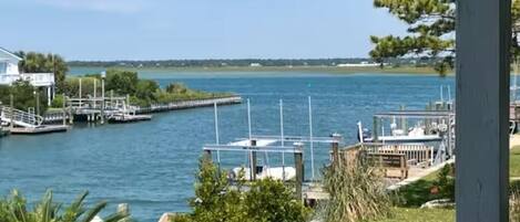 A waterfront property with a dock, a small pier, and a grassy area.
