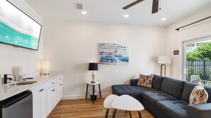 Ein modernes Wohnzimmer mit einem grauen Sofa, einem weißen Couchtisch und einem Gemälde an der Wand.