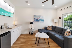 Ein modernes Wohnzimmer mit einem grauen Sofa, einem weißen Couchtisch und einem Gemälde an der Wand.