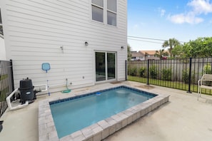 A residential swimming pool with a stone border, a grill, and a hose. - Villas at Laguna Beach #10 - Gulf Views, Pool, Rooftop Terrace, Pets OK! (Panama City Beach)