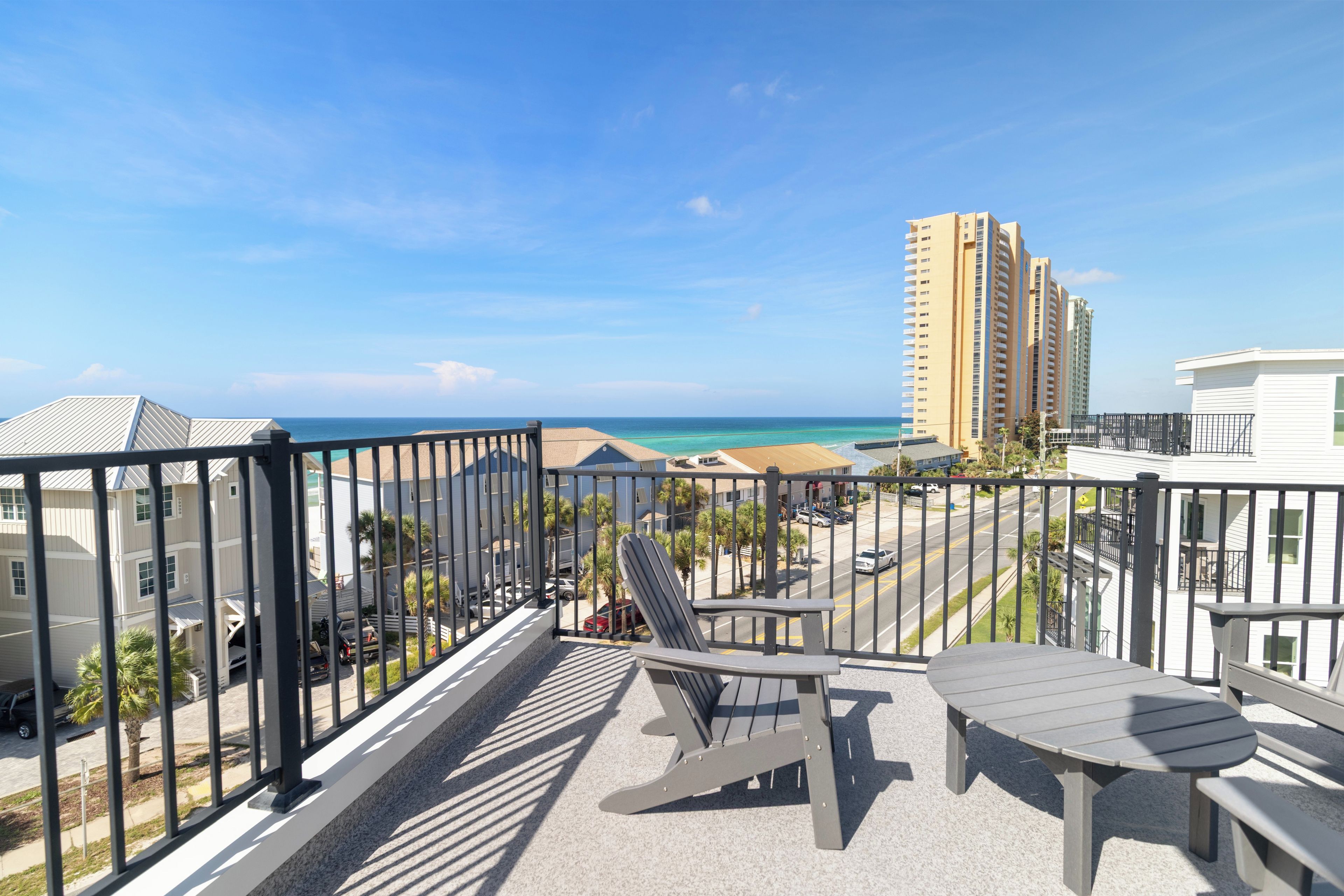Ein Balkon mit Blick auf das Meer und hohe Gebäude.