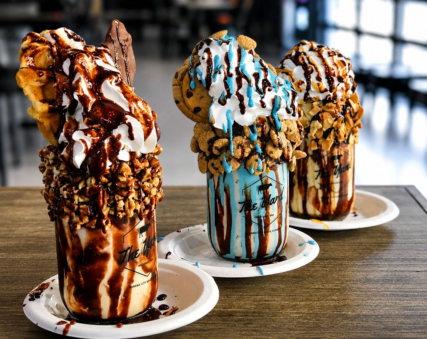 Drei Dessertgläser mit Belägen auf einem Holztisch.