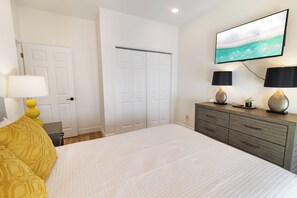 A bedroom with a bed, a dresser, a TV, and a door. - ☀️Villas Laguna #2 - Exceptional Views, Pool, Walk to Beach (Panama City Beach)
