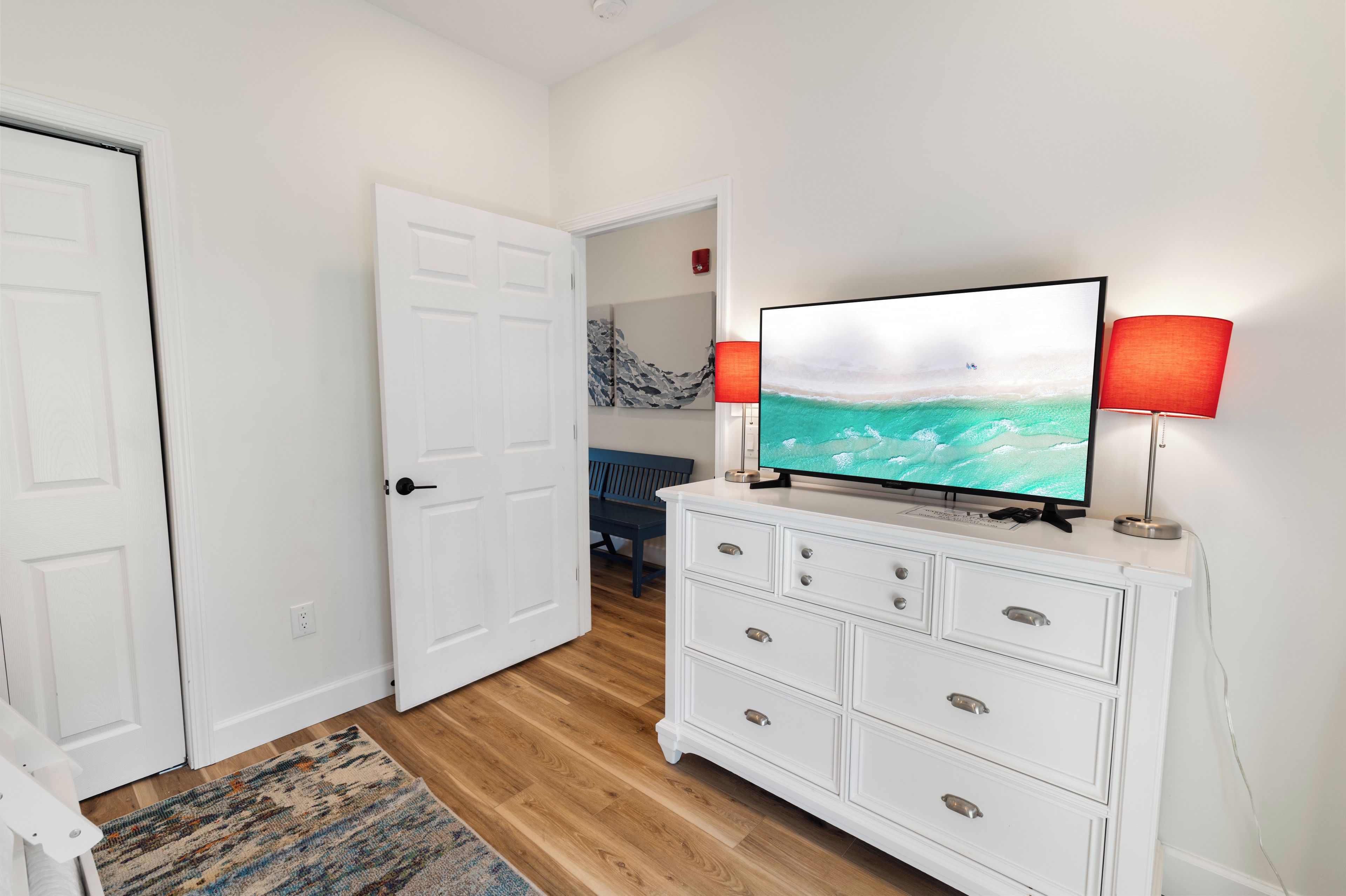 Step into your peaceful retreat with warm wood floors, coastal-inspired décor, and pops of color that brighten your stay. Your dresser offers plenty of storage, and the adjoining rooms give you flexibility and comfort.
