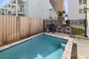 A backyard with a swimming pool, a wooden fence, and a grill. - 🌊 Villas at Laguna Beach 3 - 5 BR, Beach, Pool, Rooftop Terrace (Panama City Beach)