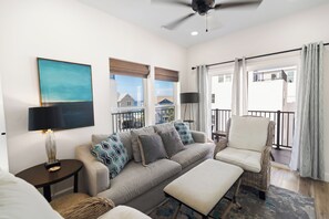 A living room with a sofa, a chair, a lamp, and a ceiling fan. - 🌊 Villas at Laguna Beach 3 - 5 BR, Beach, Pool, Rooftop Terrace (Panama City Beach)