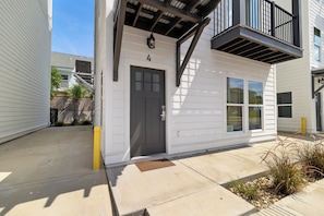 A two-story building with a grey door and windows, a visible number '4' on the facade, and a small entrance area with a doormat. - 🌊 Villas Laguna Beach #4 –  Gulf Views, Pool, Pets OK, Beach Access (Panama City Beach)