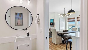 A modern bathroom with a round mirror, a sink, and a towel rack. - 🌊 Villas Laguna Beach #4 –  Gulf Views, Pool, Pets OK, Beach Access (Panama City Beach)