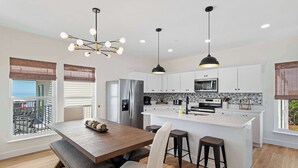 A modern kitchen with a central island, stainless steel appliances, and pendant lighting. - 🌊 Villas Laguna Beach #4 –  Gulf Views, Pool, Pets OK, Beach Access (Panama City Beach)