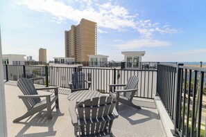 En tagterrasse med udendørs siddepladser og udsigt over byens skyline.