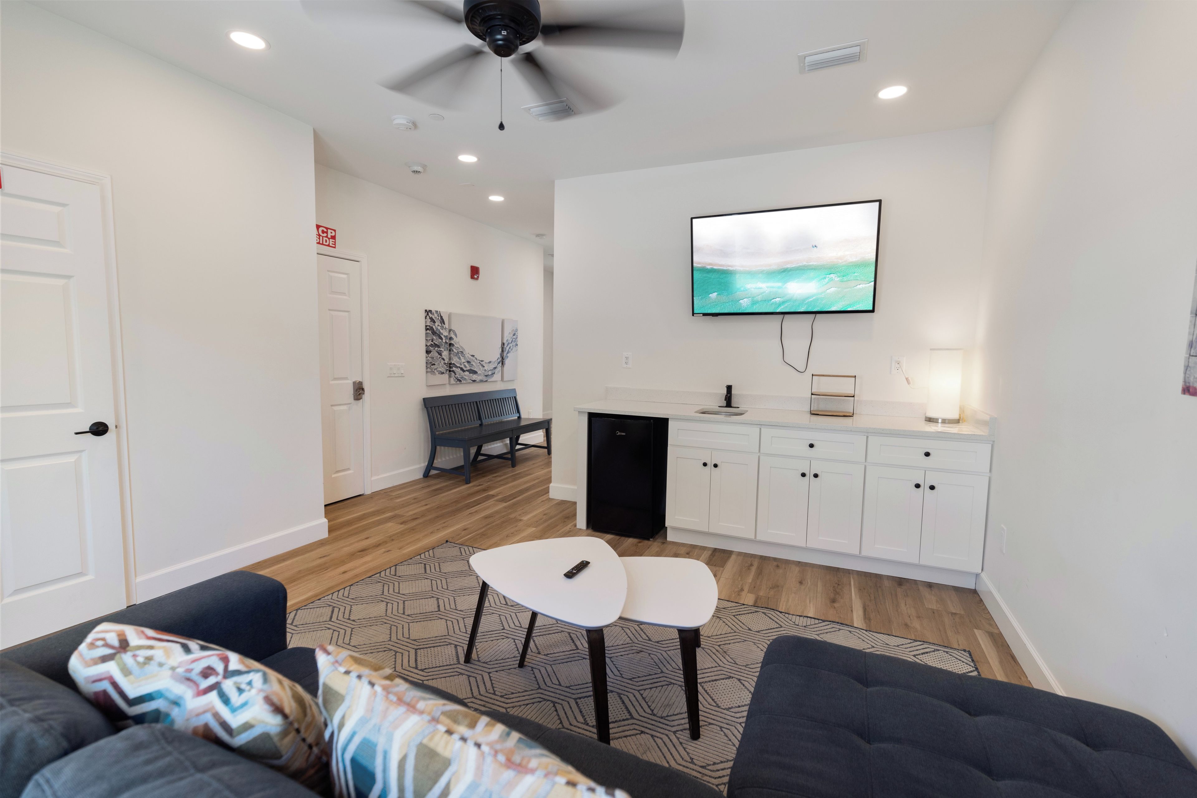 A modern living room with a sofa, a coffee table, and a TV mounted on the wall.