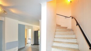 Escada com corrimão e luminária acima.