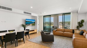 TV, books - 3BR Coastal Escape with Ocean Views, Shared Pool & Jacuzzi, 2 Car Spaces & Walk to Surf Beach (Kiama)