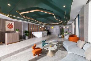 A modern lobby with a reception desk, seating area, and decorative plants. - TÂN PHƯƠNG NAM GALAXY (Da Nang)