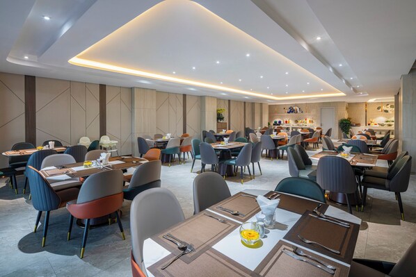 A modern dining area with multiple tables and chairs, a bar area, and a reception desk. - TÂN PHƯƠNG NAM GALAXY (Da Nang)