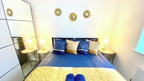 Una camera da letto con un letto, comodini e decorazioni a parete.