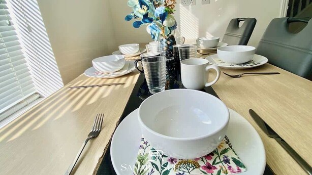 Un tavolo da pranzo con una ciotola d'acqua, una tazza e un piatto decorato con motivi floreali.