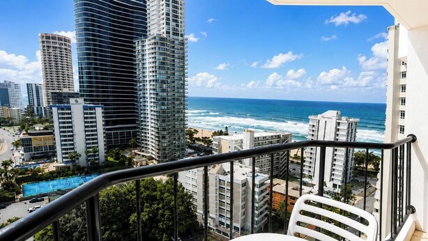 Ein Balkon mit Blick auf das Meer und hohe Gebäude.