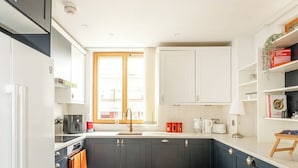 Una cocina moderna con armarios oscuros, piso de madera y una ventana con vistas.
