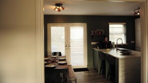 A kitchen with a dining area, a built-in island, and a ceiling light fixture. - Scenic 3BR Home with Sauna and Views (Warrenpoint, Newry)