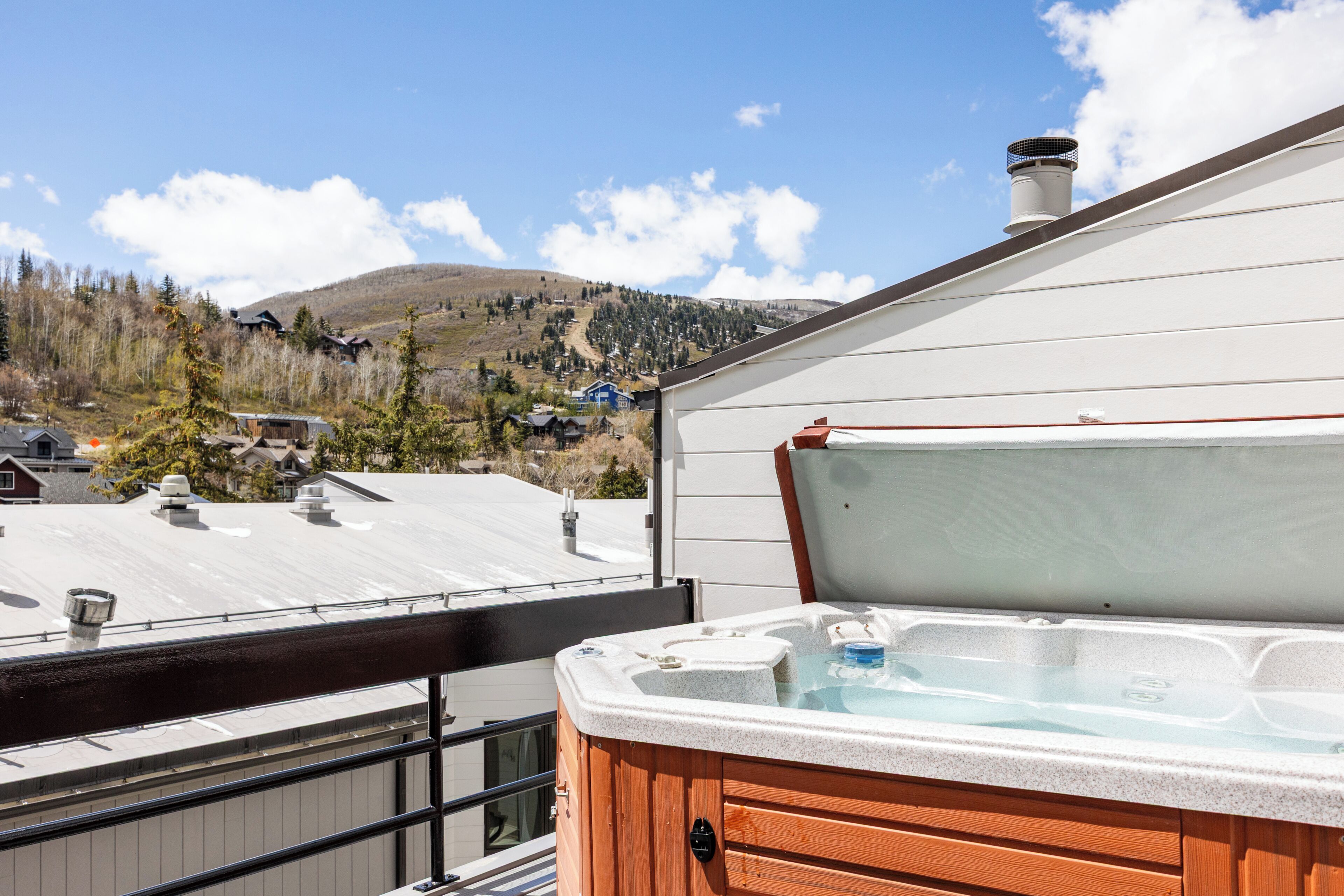 A hot tub on a balcony with a mountain view in the background.
