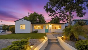 Une maison moderne dotée d’une entrée bien éclairée, d’une allée et d’un jardin aménagé.