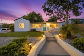 A modern house with a well-lit entrance, a driveway, and a landscaped garden. - Experience Pacific Beach Beachside Bliss: A spacious 5-bedroom home for 12 (San Diego)