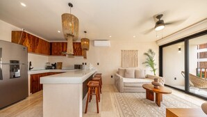 Een moderne keuken met een centraal eiland, houten kastjes en hanglampen.