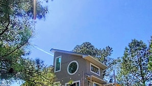 A two-story house with a wooden deck and stairs.