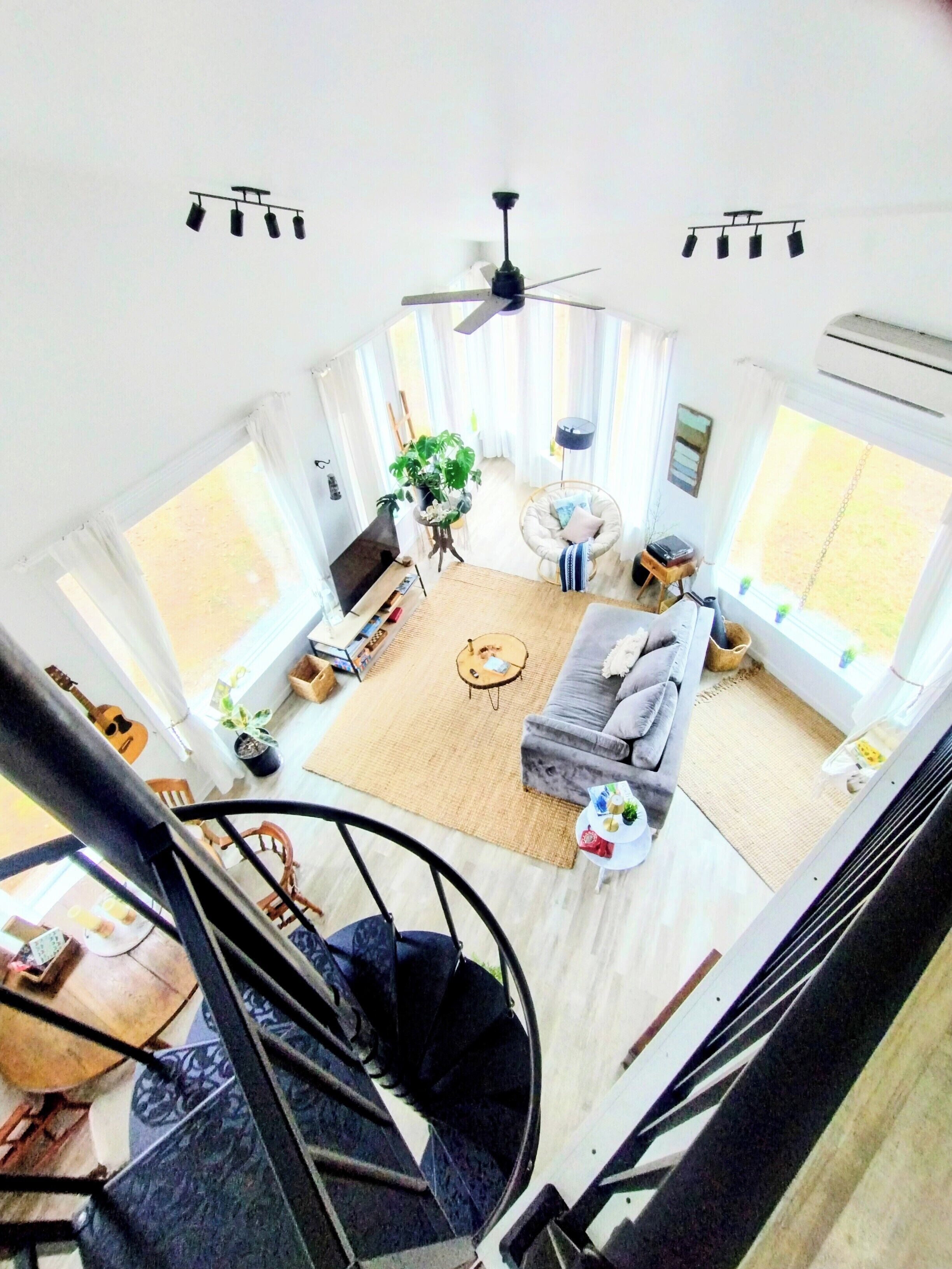 A spacious living room with a sofa, coffee table, and a ceiling fan.