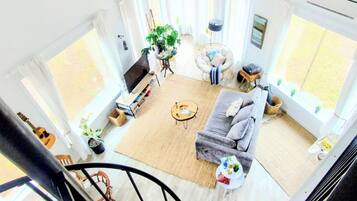 A spacious living room with a sofa, coffee table, and a ceiling fan.