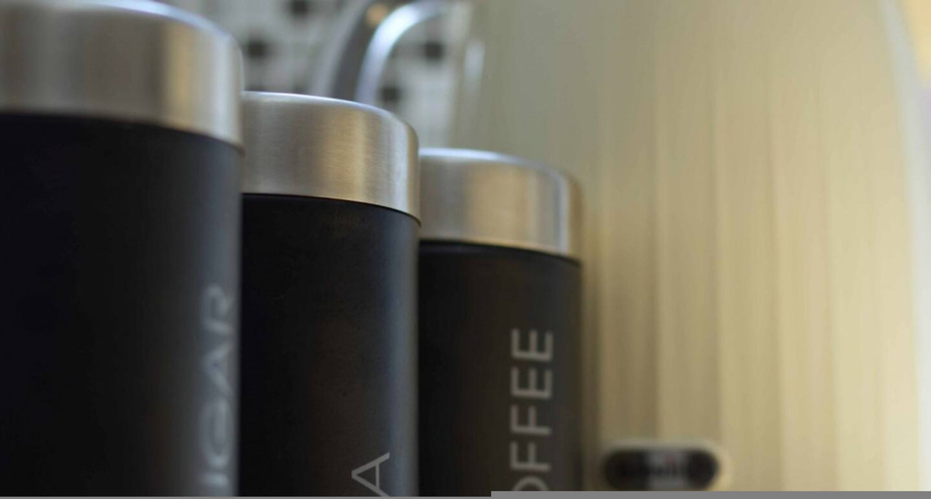 A row of black coffee machines with the word 'COFFEE' visible on one of them.