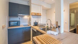 A compact kitchen with a toaster, sink, and wooden countertop. - Cosy Mont-Blanc – Centre Chamonix - Welkeys (Chamonix-Mont-Blanc)