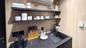 A modern kitchen with a built-in sink, a coffee machine, and a set of knives on the counter. - Luxury Mirror Cabin with Lake View - Nature (Mountainburg)