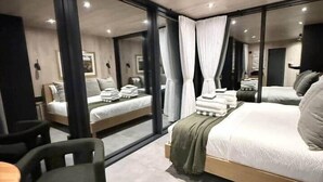 A modern hotel room with a large bed, a desk, and a chair. - Luxury Mirror Cabin with Lake View - Nature (Mountainburg)