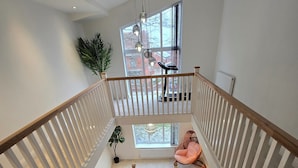 A modern staircase with white railings and a carpeted floor leading to a balcony with a view. - Cozy Urban Retreat in Wolverhampton (Wolverhampton)