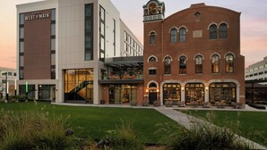 Un hotel con un edificio moderno e una struttura in mattoni tradizionali, entrambi dotati di aree salotto all'aperto.
