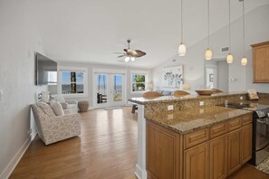 A modern kitchen with granite countertops, wooden cabinets, and a built-in oven.