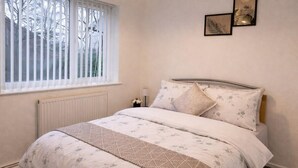 Ein Schlafzimmer mit Bett, Fenster und Wanddekoration.