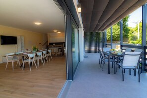 A modern interior with a dining area, kitchen, and a covered outdoor space with seating. - Modern villa with pool near Ivanščica and Varaždin (Margečan)
