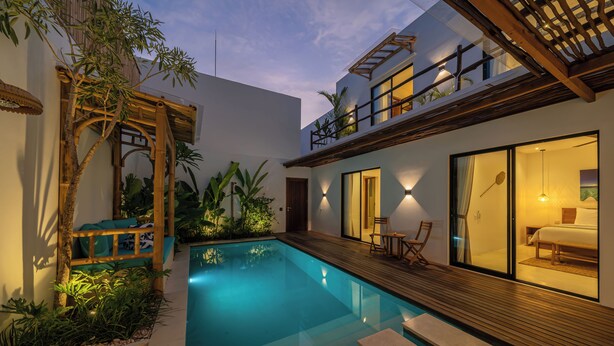 A modern house with a swimming pool, wooden deck, and a bedroom with a bed and nightstand. - Villa Irena (Canggu)